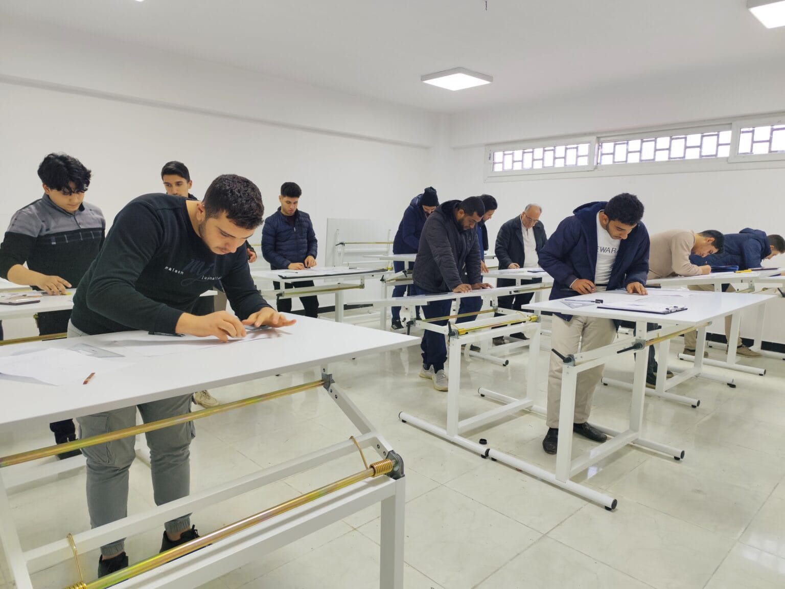 طلاب كلية هندسة البناء وإعادة الإعمار أثناء التدريب العملي على الرسم الهندسي