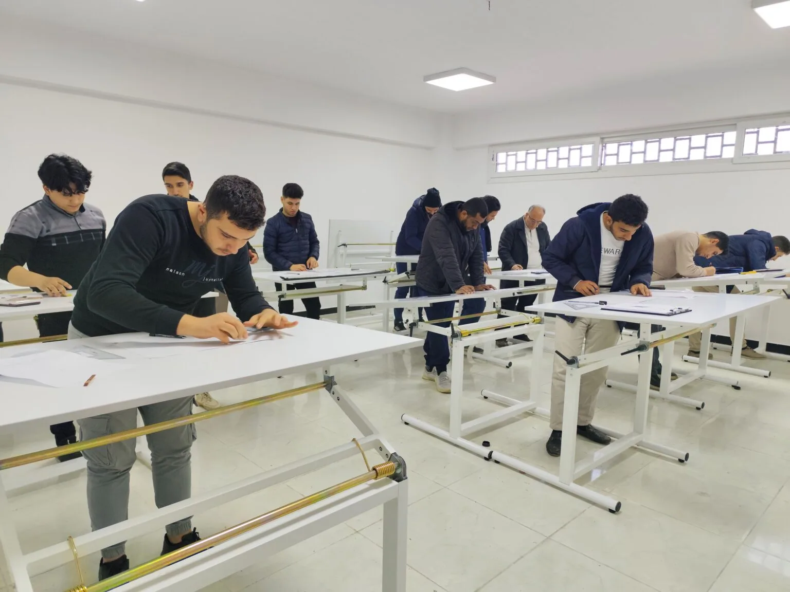 طلاب كلية هندسة البناء وإعادة الإعمار أثناء التدريب العملي على الرسم الهندسي